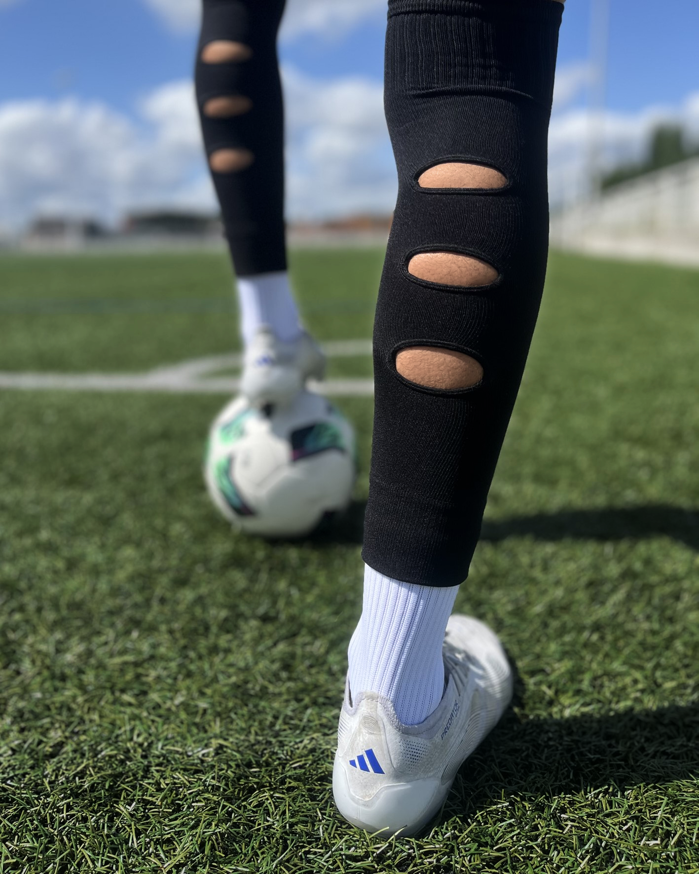 Chaussettes-a-trous-football, Manchons de football, precut socks ou jambières, couleur noir, portées sur terrain de football | Game Changer