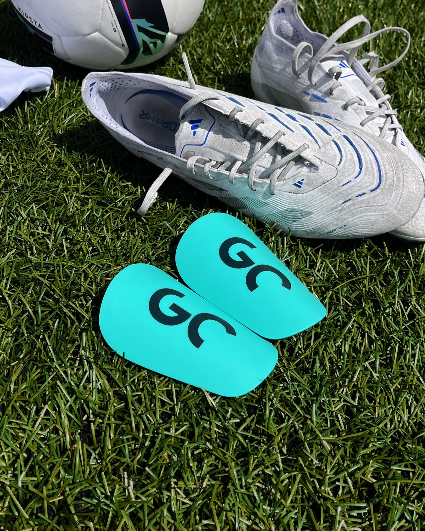 Mini protège-tibias discrets pour footballeurs confort et compacts, posées sur terrain de football| Game Changer